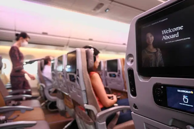 A row of empty seats (L) are seen on board a Singapore Airlines flight