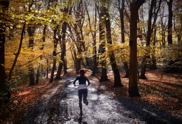Woman running through woodland