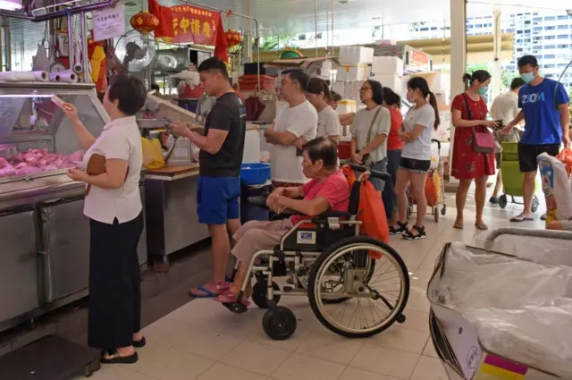 People lining up at a Singapore market stall