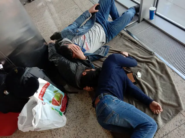 People are pictured lying on the floor at Sheremetyevo airport