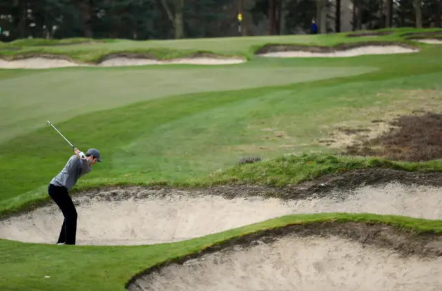 A golfer plays out of a bunker at Sunningdale golf course in England