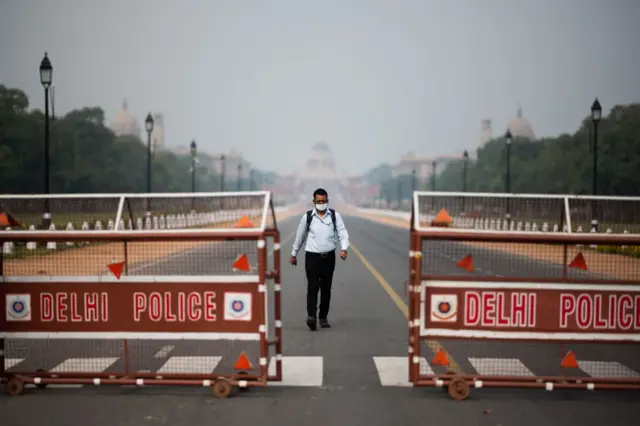 A man walks on a deserted Rajpath leading to the Presidential Palace during a government-imposed lockdown as a preventive measure against the COVID-19 coronavirus in New Delhi on March 24, 2020