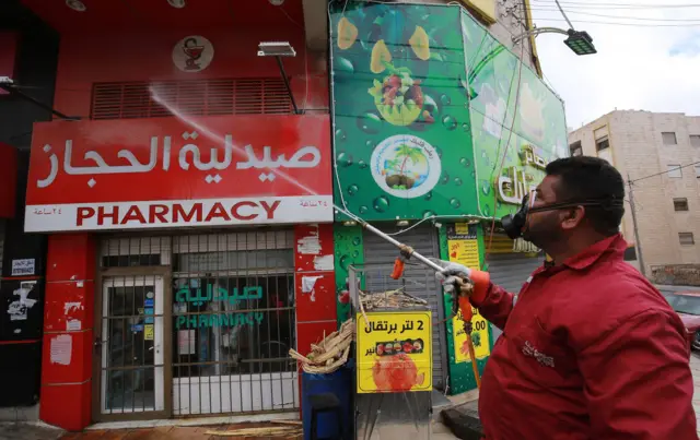 Worker disinfects a pharmacy in Amman, Jordan (21/03/20)