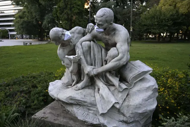 Sculptures at Plaza San Martin square wear face masks made of paper in Buenos Aires, Argentina on 23 March, 2020.