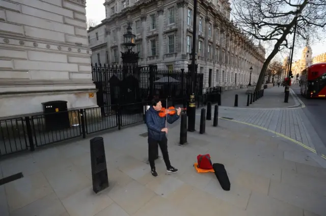 As Boris Johnson prepared to make his announcement, a lone violinist played on an empty Whitehall, near Downing Street