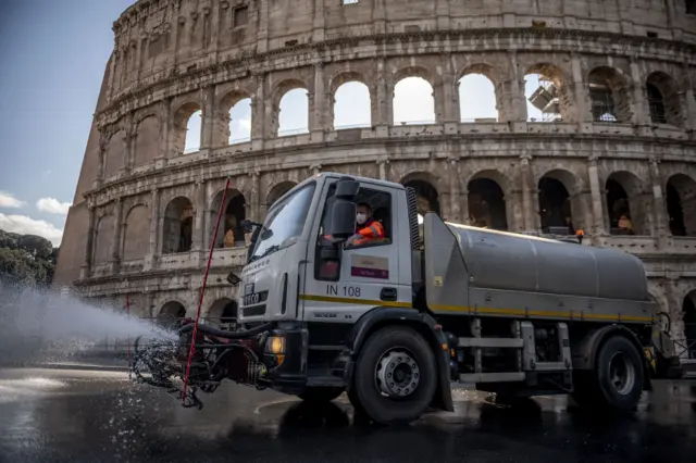 A worker drives a tanker truck spraying cleaning liquid to sanitise the Colosseum (Colosseo) area during the coronavirus emergency in Rome, Italy, 24 March 2020