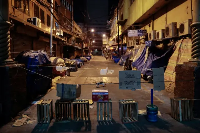 A cat walks across a street blocked with fruit crates and makeshift barricades to protect a neighborhood from the spread of the coronavirus disease (COVID-19) in Manila, Philippines, March 24, 2020.