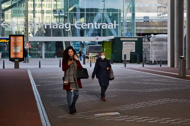 Commuters walk outside a train station