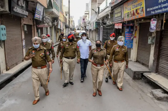 Police personnel patrol on a street during a government-imposed lockdown as a preventive measure against the COVID-19 coronavirus, in Amritsar on March 24, 2020. (