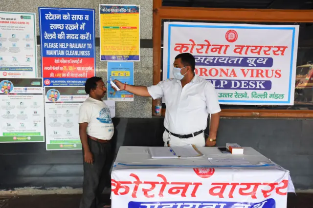 People undergo thermal screening as a precautionary measure amid rising coronavirus concerns, at New Delhi Railway Station on March 23, 2020 in New Delhi, India