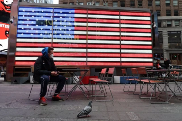 Man sitting in front of US flag