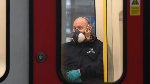 Man wearing personal protective equipment on the Tube in London