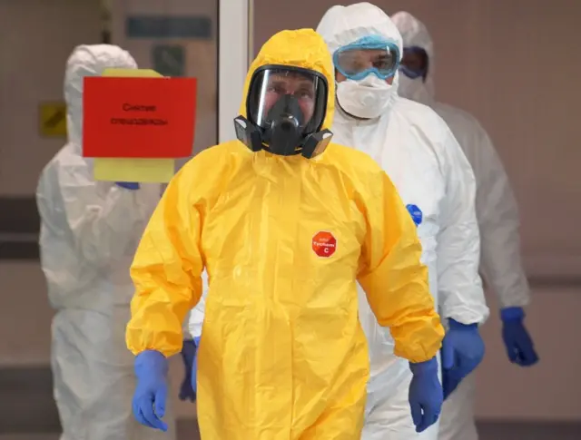 Russian President Vladimir Putin wearing protective gear visits a hospital where patients infected with the coronavirus are being treated in the settlement of Kommunarka in Moscow on 24 March 2020