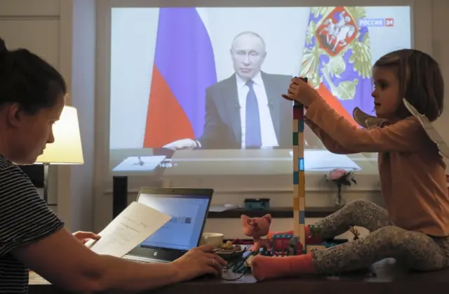 A Russian family near Moscow watch President Vladimir Putin’s address. Photo: 25 March 2020