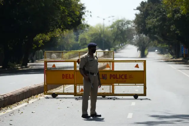 A policeman stands guard at a road checkpoint the day after Indian Prime Minister Narendra Modi announced a 21-day government-imposed nationwide lockdown.