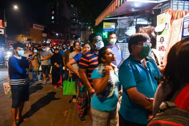 People gather at a pharmacy to buy supplies