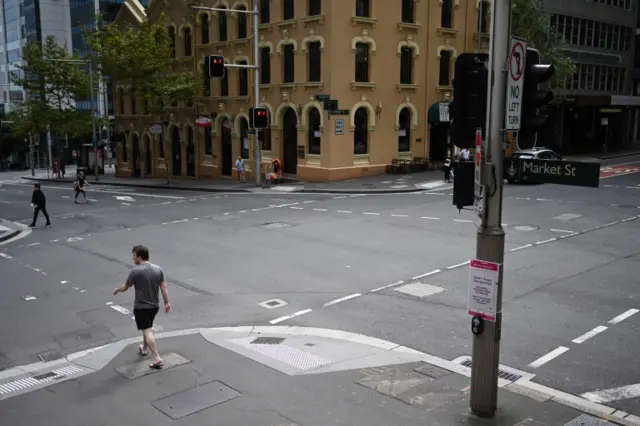 People cross empty streets in Sydney's CBD