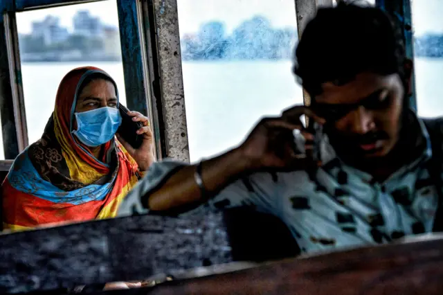 A passenger wearing a face mask as a precaution against the spread of Coronavirus sits in a ferry.