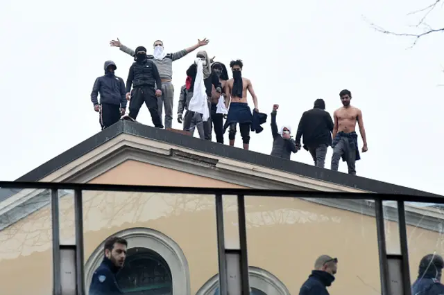 Italian prisoners stand on roof of jail