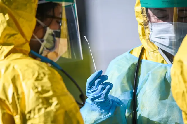 Health care professionals test for COVID-19 at a testing site in Jericho, New York