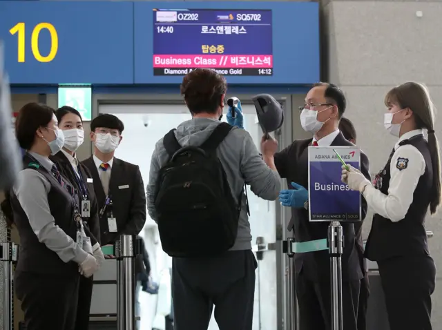 Passengers bound for the US undergo a body temperature check at Incheon International Airport