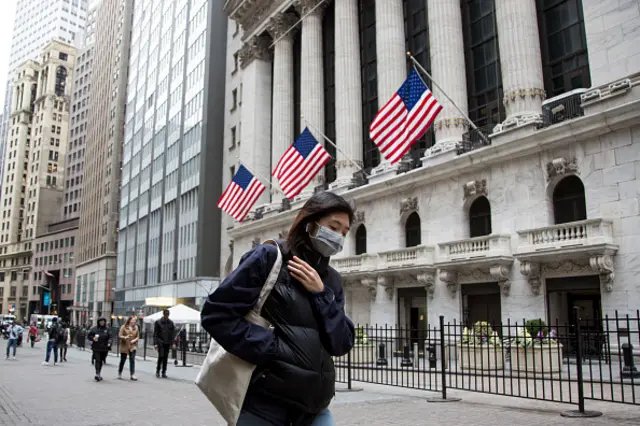 A woman walks on Wall Street