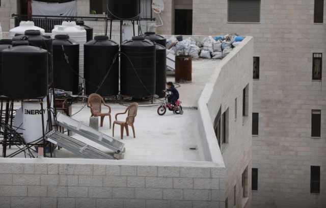 A Palestinian child cycles on the roof of a building in the city of Nablus, in the occupied West Bank (26 March 2020)