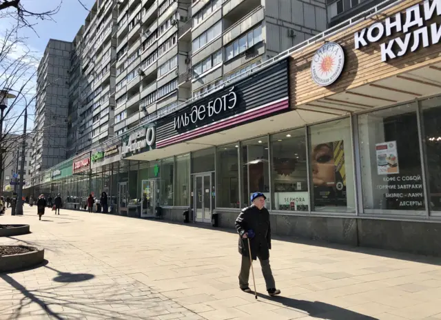 An old lady walks along a street in Moscow