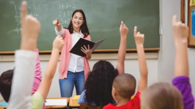 Teacher in front of a class of young students