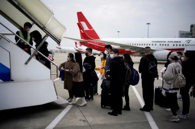 Passengers prepare to board a plane in Shanghai