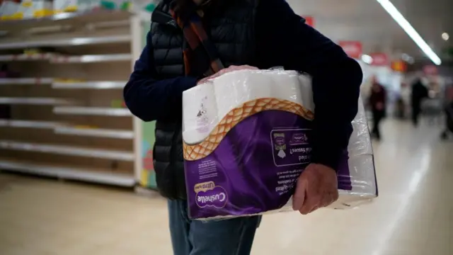 Man carrying toilet roll