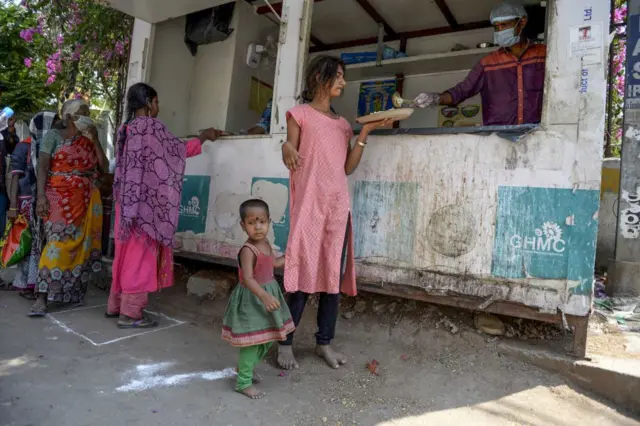 Homeless people receive free food offered by the Telangana state government