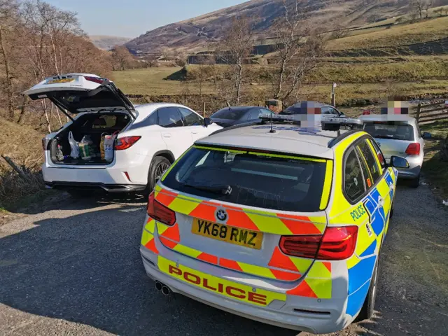 Police car amid vehicles in the Peak District