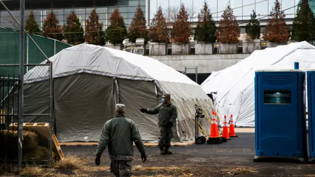 Workers and Military Members build a makeshift morgue outside of Bellevue