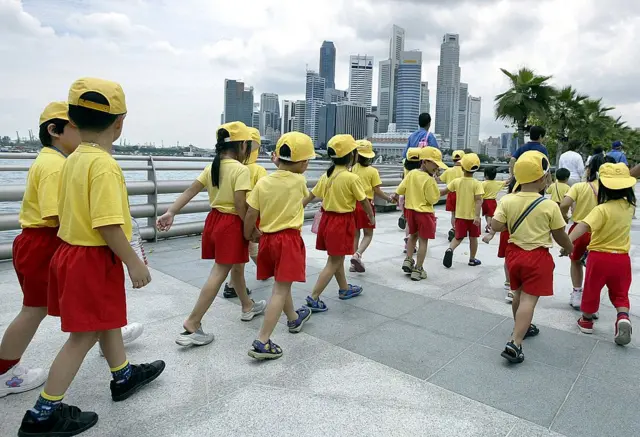 Singapore pre-school children walk along the bay