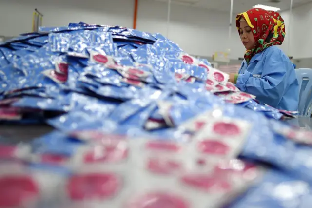 a worker packs condoms at the Malaysian condom-maker Karex Industries headquarters in Port Klang