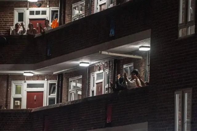 People in London clap on their balconies