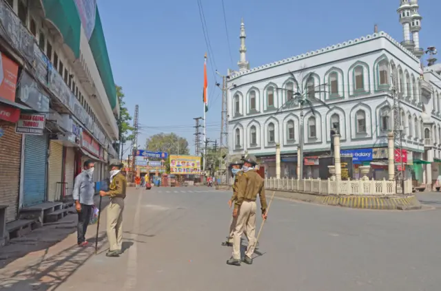 Police officials wear mask as they patrol during curfew imposed by the authorities in order to control the spread of the deadly coronavirus 'COVID-19' in Bhilwara.