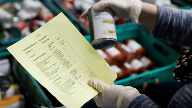 volunteer holding tinned food