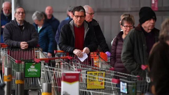 people queuing with trolleys