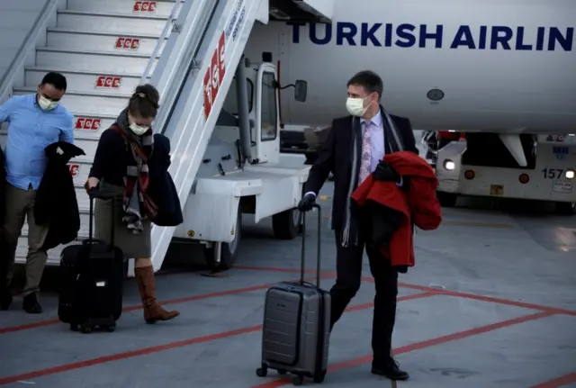 A passenger wears a protective face mask in light of the coronavirus, upon arrival at Istanbul Airport, Turkey