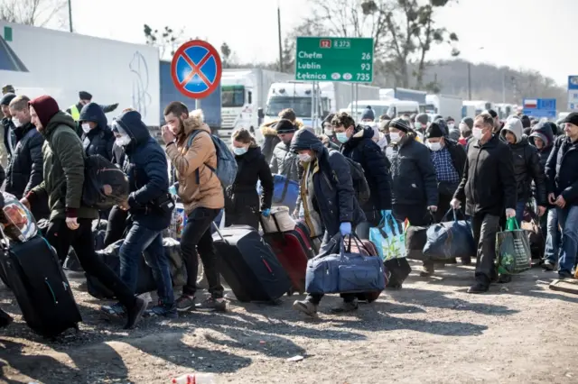 People queue to cross to Ukraine following planned border closing