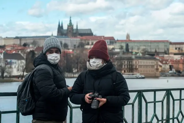 Tourists wearing face masks are seen close to the Vltava river in Prague