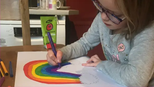 Child drawing a rainbow