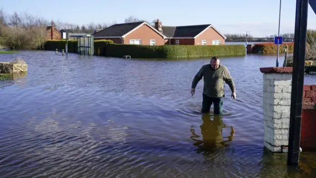 A man walking through floodwater