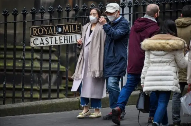 Folk wearing masks on the Royal Mile