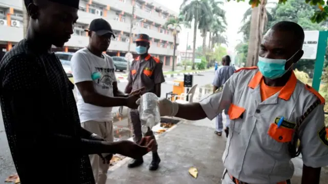 Visitors using a hand sanitiser at a state hospital in Lagos
