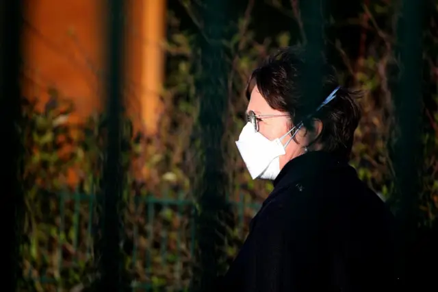 A member of staff at a school in northern France wears a face mask (3 March 2020)