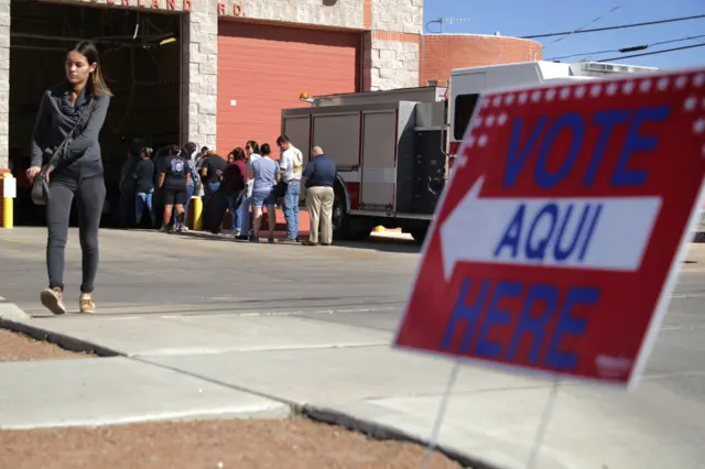 Voters line up outside the polling place at Fire Station