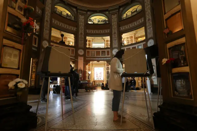 A voter fills out her ballot in a polling station at the San Francisco Columbarium & Funeral Home